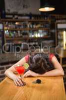 Drunk woman driver leaning on counter with her cocktail