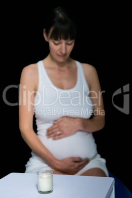 Pregnant woman and glass on table