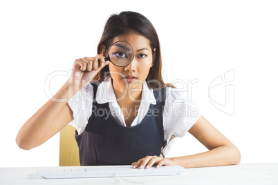 Businesswoman looking through magnifying glass