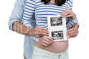 Pregnant couple holding ultrasound scan