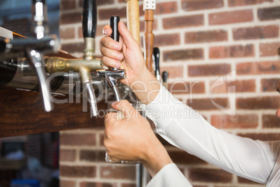 Masculine hands pouring beer