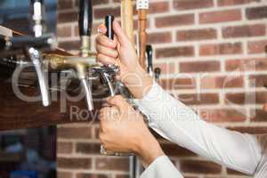 Masculine hands pouring beer