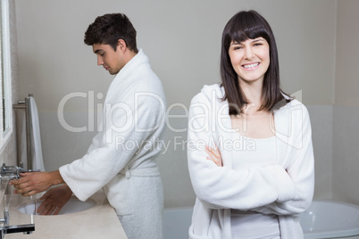 Woman looking at camera and man standing near sink