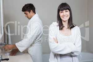 Woman looking at camera and man standing near sink