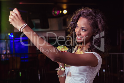 Young women taking a selfie while having a cocktail drink