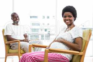 Pregnant couple sitting on chair