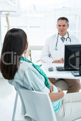 Doctor interacting with a pregnant woman at clinic
