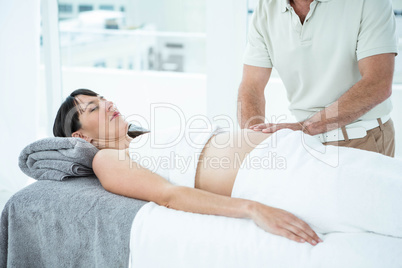 Pregnant woman receiving a stomach massage from masseur