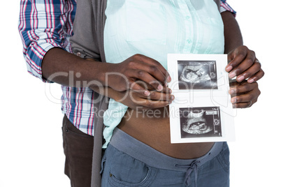 Pregnant couple holding ultrasound scan