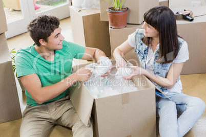 Young couple unpacking carton boxes in their new house