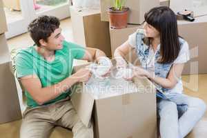 Young couple unpacking carton boxes in their new house