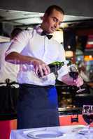 Waiter pouring wine in a glass