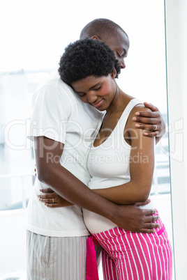 Pregnant couple cuddling each other