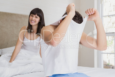 Man removing his vest in front of woman