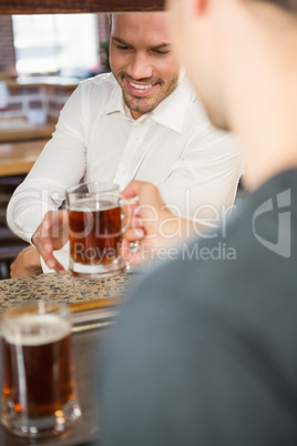 Handsome bar tender giving a pint to customer