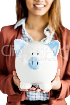 Businesswoman holding a piggy bank