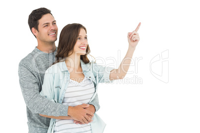 Couple embracing and pointing up