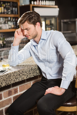 Tired man leaning his elbow on the counter