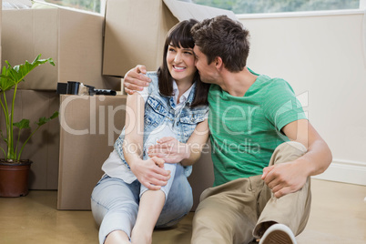 Young couple sitting together on the floor and smiling