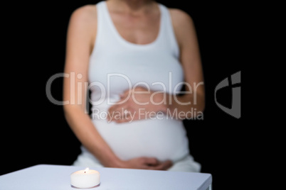 Pregnant woman and glass on table