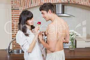 Man giving red rose to woman