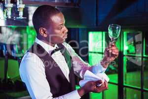 Barkeeper checking a wine glass after cleaning