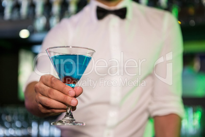 Bartender serving a blue martini