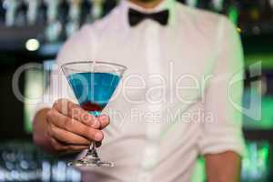 Bartender serving a blue martini