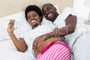 Pregnant couple looking at mobile phone