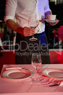 Waiter setting a table