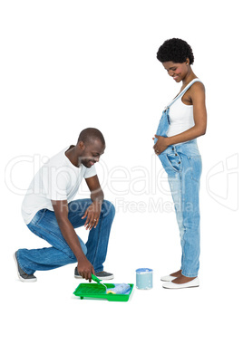 Pregnant couple with blue paint tin