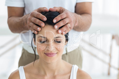 Pregnant woman receiving a head massage from masseur