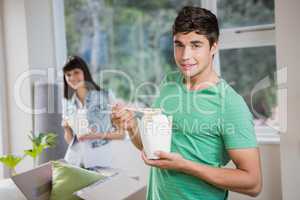 Young man and woman eating noodles at home