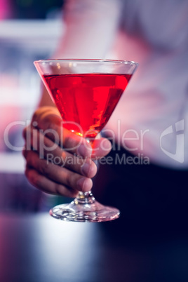 Bartender serving a red martini