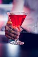 Bartender serving a red martini
