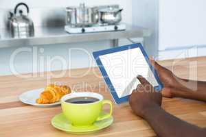Man using digital tablet while having breakfast