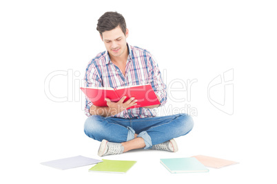 Man reading a book while sitting on the floor