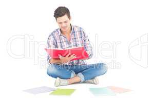 Man reading a book while sitting on the floor