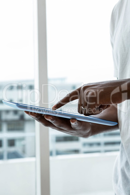 Man using digital tablet near window