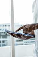 Man using digital tablet near window