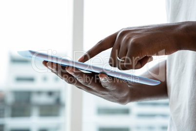 Man using digital tablet near window