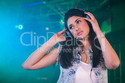 Pretty female DJ listening music on headphone