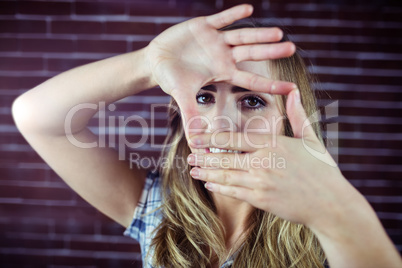 Pretty blonde woman looking through her hands