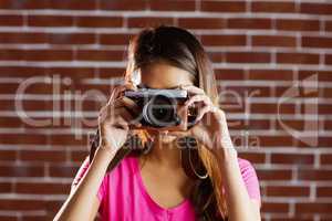 Smiling asian woman taking picture with camera