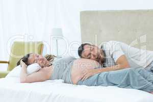 Man listening the belly of pregnant woman