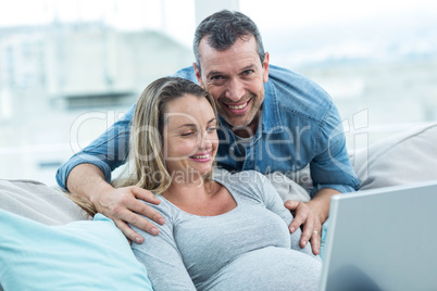 Couple using laptop in living room