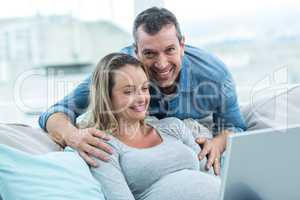 Couple using laptop in living room