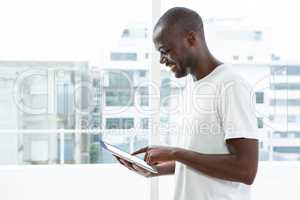 Man using digital tablet near window