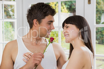 Man offering a red rose to woman