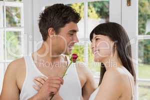 Man offering a red rose to woman